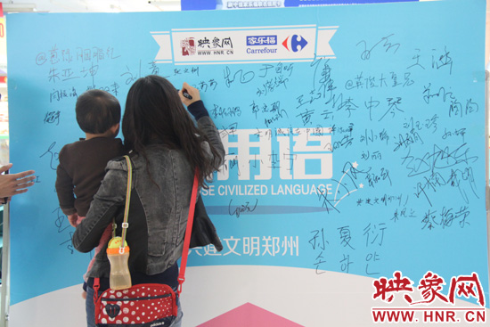 市民在活動(dòng)簽名板上簽字支持使用文明用語(yǔ) 市民在活動(dòng)簽名板上簽字支持使用文明用語(yǔ)