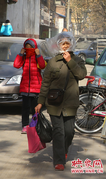 一位路人用塑料袋遮塵