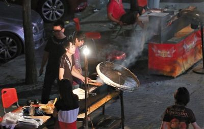 7月4日，青年路國美第一城小區(qū)附近的夜市臨街露天燒烤攤。