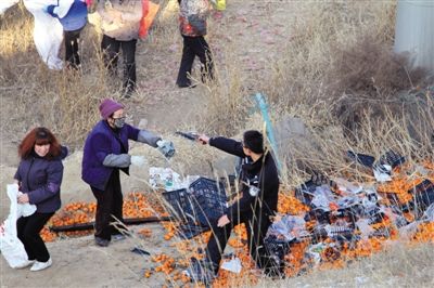 1月4日，連霍高速蘭州市榆中縣和平鎮(zhèn)段，一名警察舉著槍驅(qū)散哄搶橘子的村民。圖/CFP