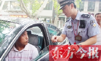 交警為車主講解“挪車請撥打114轉(zhuǎn)車主”的提示牌的使用方法