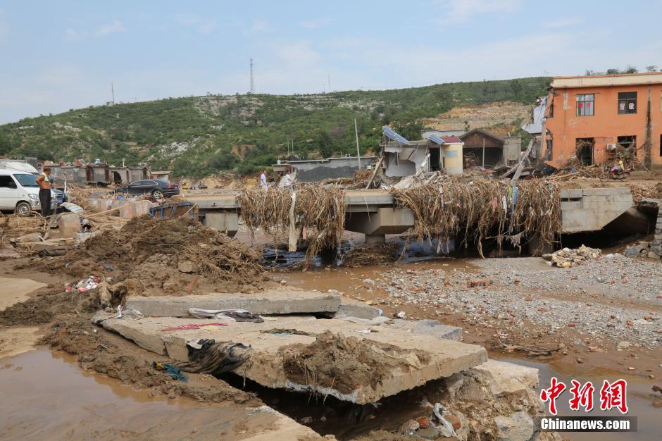 圖為洪水過后，坍塌的橋梁上遺落大量雜草。