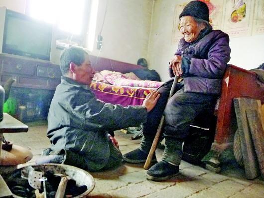 52歲的劉蘭山每天靠爬行照顧90歲的老母親。孫國(guó)祥 攝