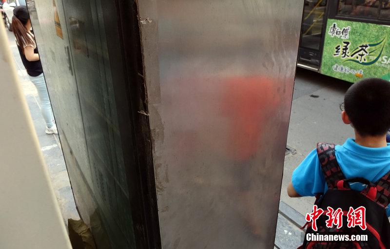 鄭州現(xiàn)最窄公交站牌 市民隔縫看線路